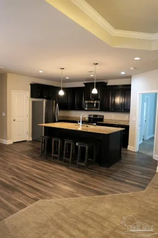 a large kitchen with a large counter top stainless steel appliances and cabinets