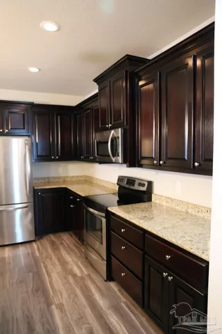a kitchen with granite countertop wooden cabinets and stainless steel appliances