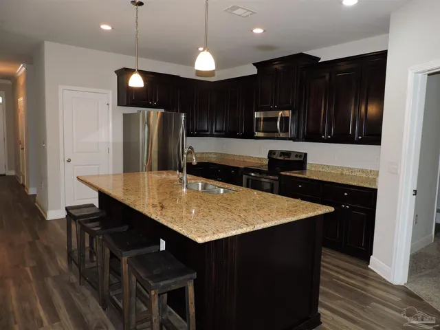 a kitchen with stainless steel appliances granite countertop a refrigerator a sink and a stove