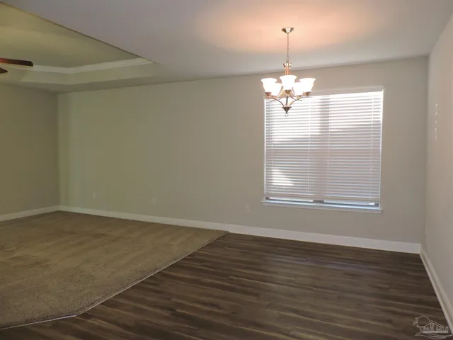 a view of a room with wooden floor and chandelier