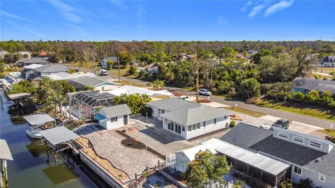 a kitchen with a sink a stove and chairs with white walls