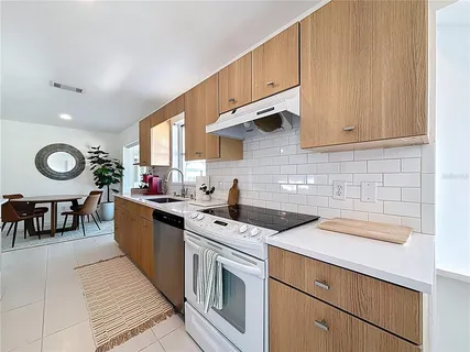a kitchen with stainless steel appliances a sink a refrigerator and cabinets