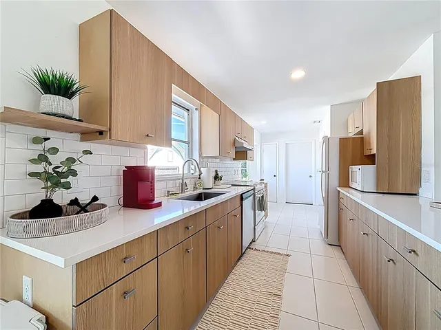 a large white kitchen with a stove a sink and a refrigerator