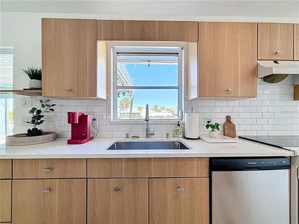 a kitchen with a refrigerator a sink and a dining table