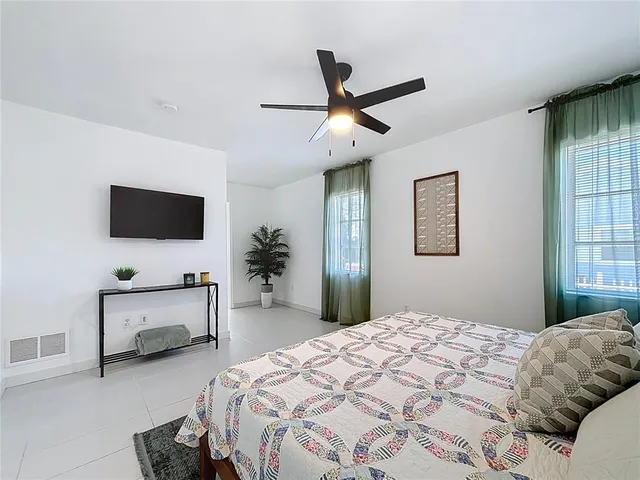 a bedroom with a bed a flat screen tv and a couch