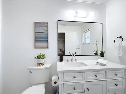 a bathroom with a double vanity sink toilet and a mirror