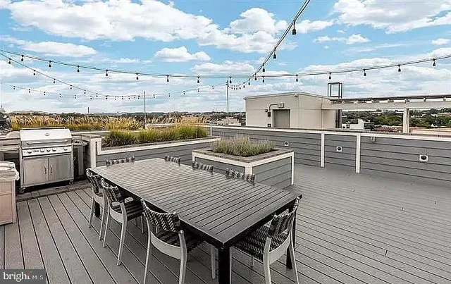 a view of a roof deck with table and chairs