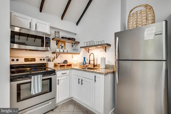 a kitchen with stainless steel appliances granite countertop a refrigerator and a stove top oven