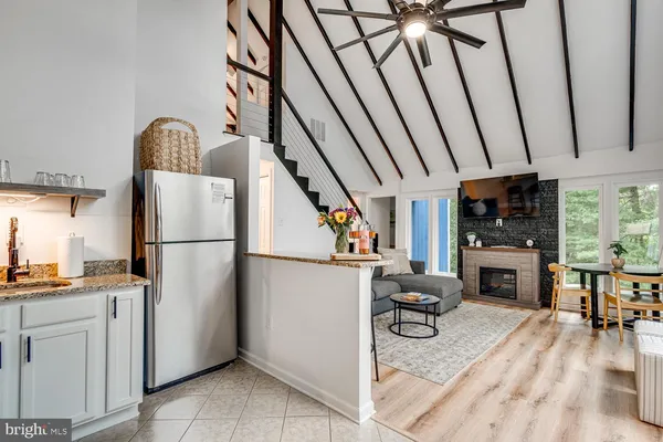 a kitchen with stainless steel appliances granite countertop a refrigerator a sink a stove and white cabinets