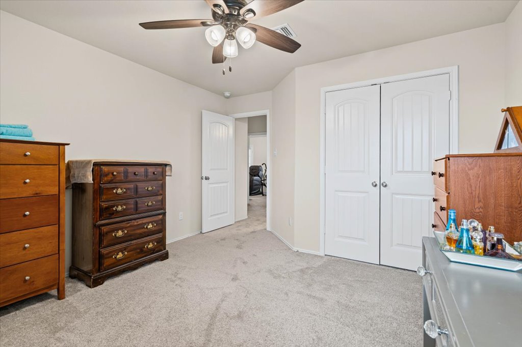 212 Plata Lane Jarrell, TX 76537 - Photo 19 of 29 Bedroom with light colored carpet, ceiling fan, and a closet