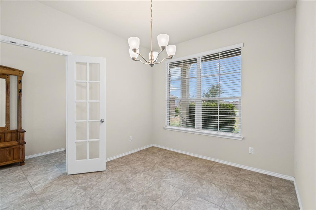 212 Plata Lane Jarrell, TX 76537 - Photo 6 of 29 Empty room featuring a chandelier and baseboards