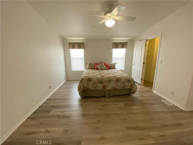 a bedroom with a bed and wooden floor