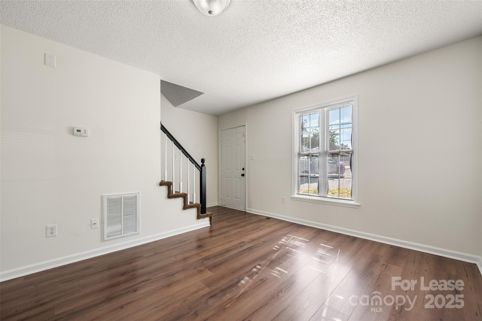 608 Bethpage Road Kannapolis, NC 28081 - Photo 4 of 37 a view of an empty room with wooden floor and a window