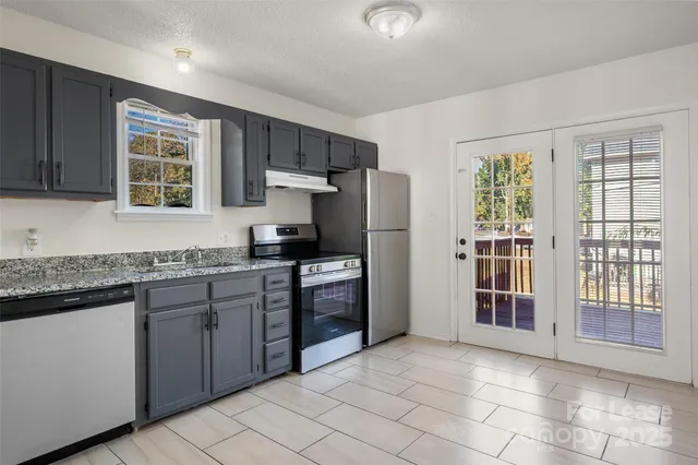 a kitchen with stainless steel appliances granite countertop a refrigerator and a sink