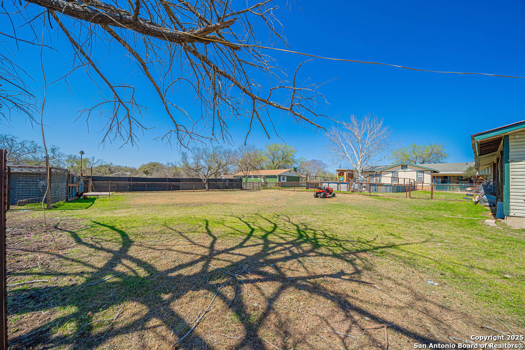 10544 Macaway Road Adkins, TX 78101 - Photo 18 of 40 a view of a swimming pool with a table under an umbrella