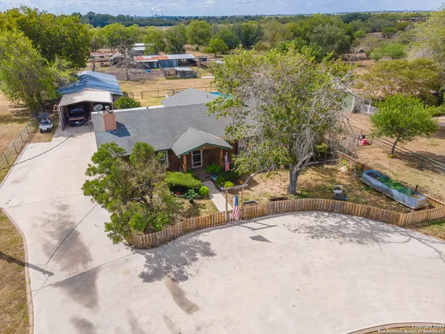 an aerial view of a house with a yard and lake view