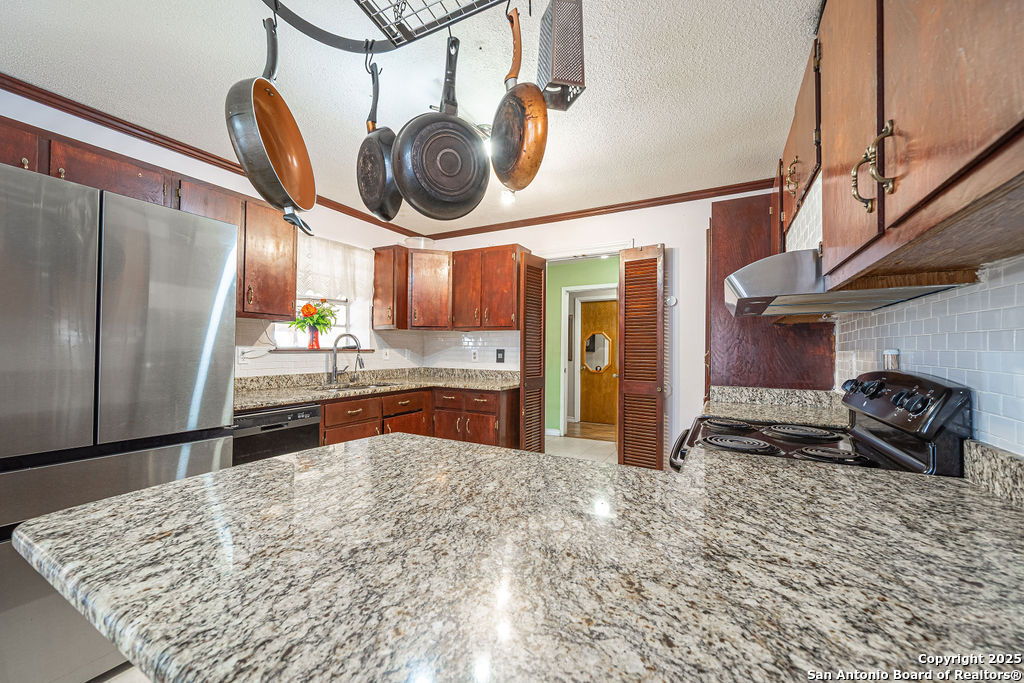 10544 Macaway Road Adkins, TX 78101 - Photo 33 of 40 a kitchen with stainless steel appliances granite countertop a sink a stove and a refrigerator