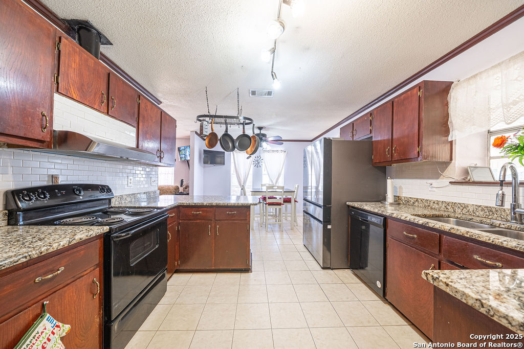 10544 Macaway Road Adkins, TX 78101 - Photo 34 of 40 a kitchen with stainless steel appliances granite countertop a stove a sink dishwasher a refrigerator and a oven