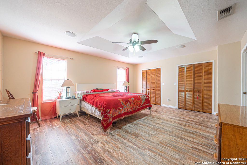 10544 Macaway Road Adkins, TX 78101 - Photo 35 of 40 a spacious bedroom with a bed and wooden floor