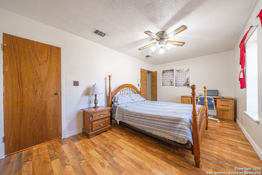 10544 Macaway Road Adkins, TX 78101 - Photo 37 of 40 a bedroom with a bed and a chandelier