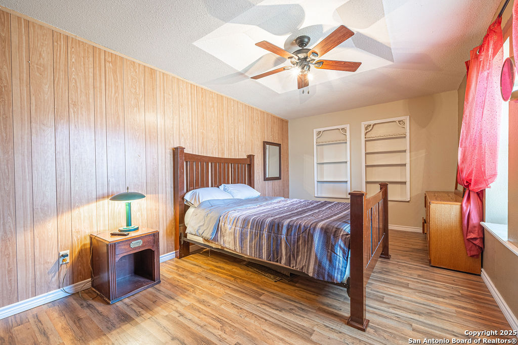10544 Macaway Road Adkins, TX 78101 - Photo 38 of 40 a spacious bedroom with a bed and a chandelier
