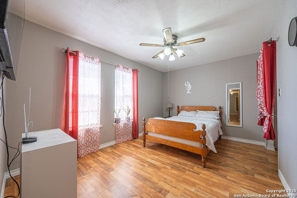 10544 Macaway Road Adkins, TX 78101 - Photo 39 of 40 a bedroom with a bed and a chandelier