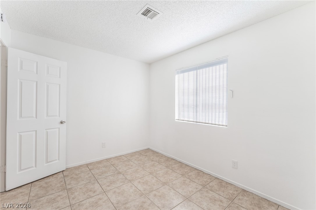 2257 Exeter Drive, Unit B Las Vegas, NV 89156 - Photo 23 of 39 Unfurnished room featuring a textured ceiling and light tile patterned flooring