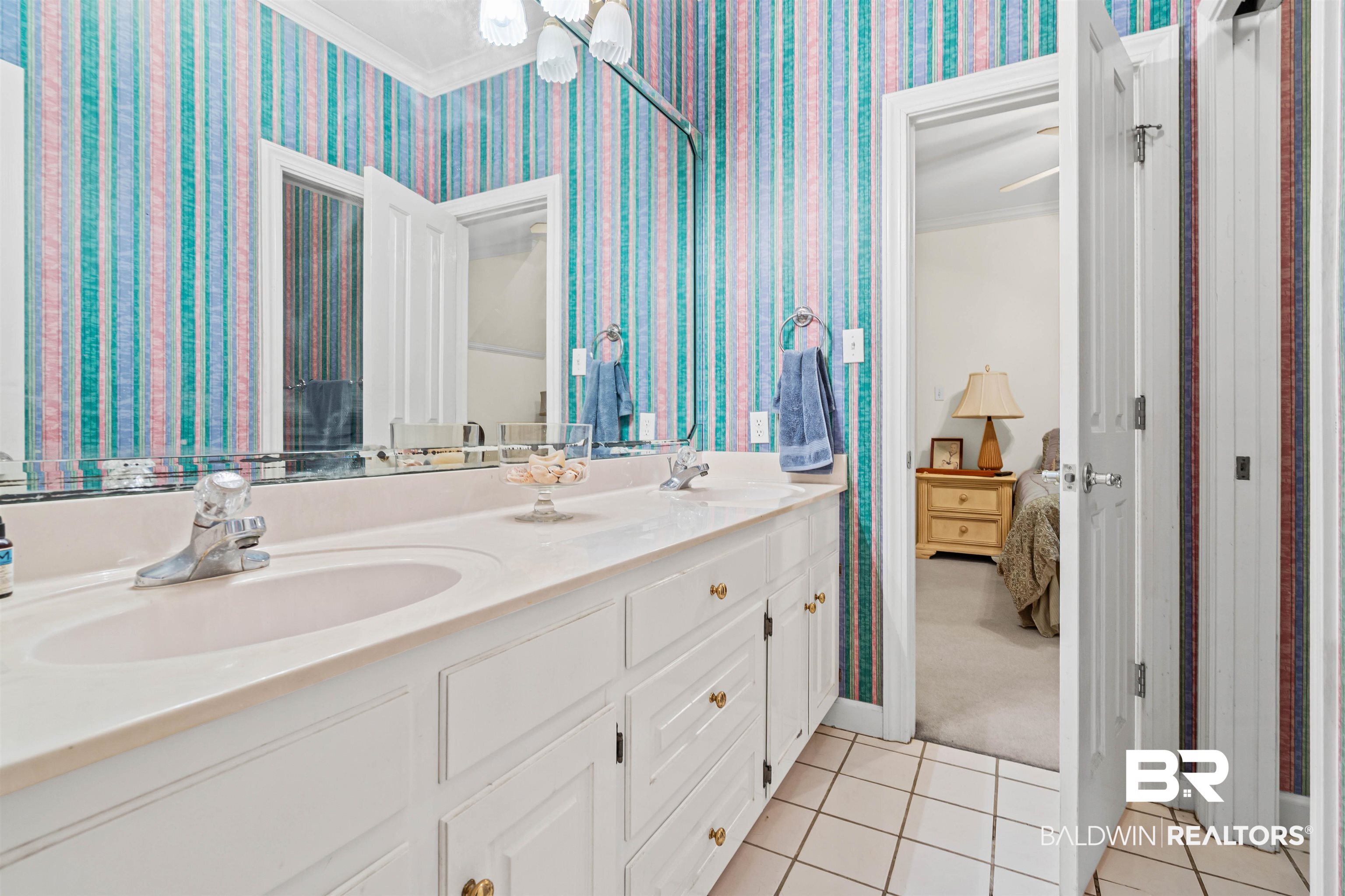 107 Beaver Dam Road Fairhope, AL 36532 - Photo 24 of 45 Full bathroom with ornamental molding, light tile patterned flooring, double vanity, wallpapered walls, and light carpet