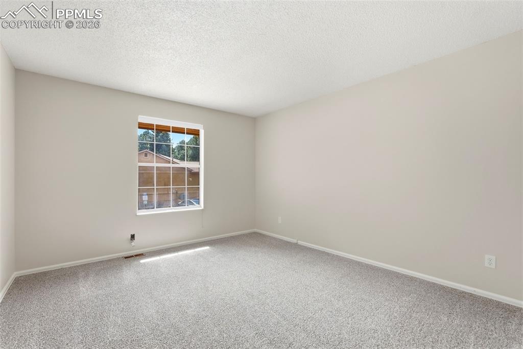 240 Bennington Drive Colorado Springs, CO 80906 - Photo 26 of 44 This inviting room features a window providing natural light, neutral-toned walls, and a light-colored carpet
