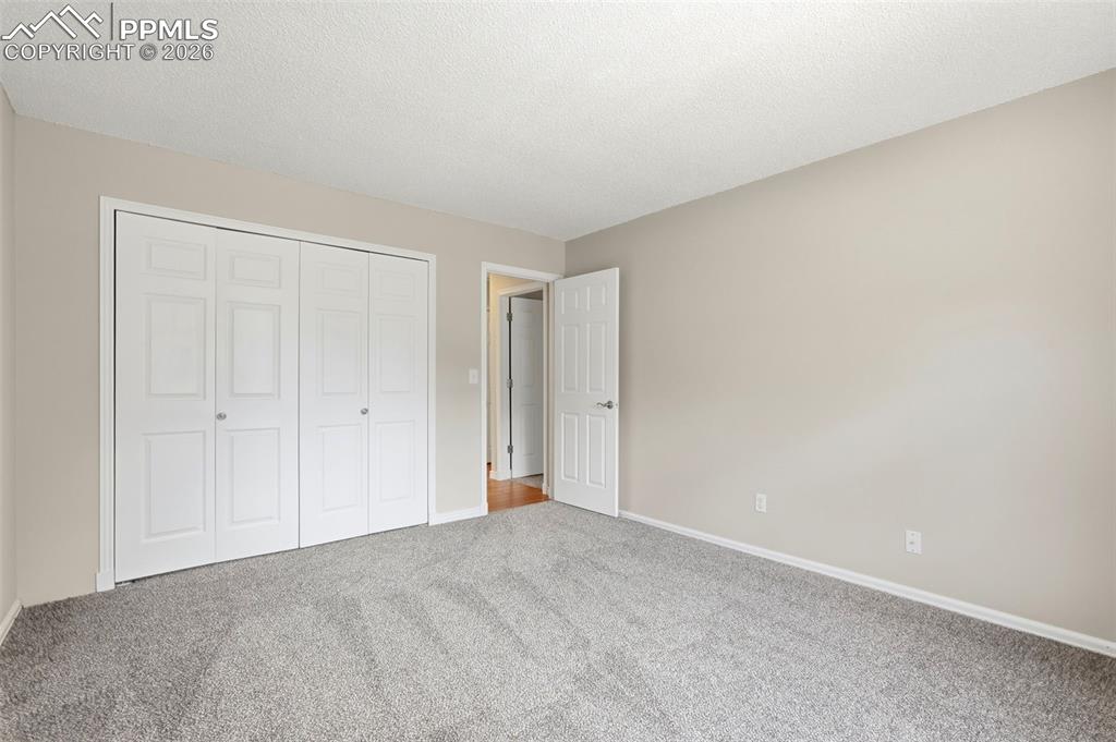 240 Bennington Drive Colorado Springs, CO 80906 - Photo 27 of 44 This room features light grey carpeting, neutral-toned walls, and a white bi-fold closet