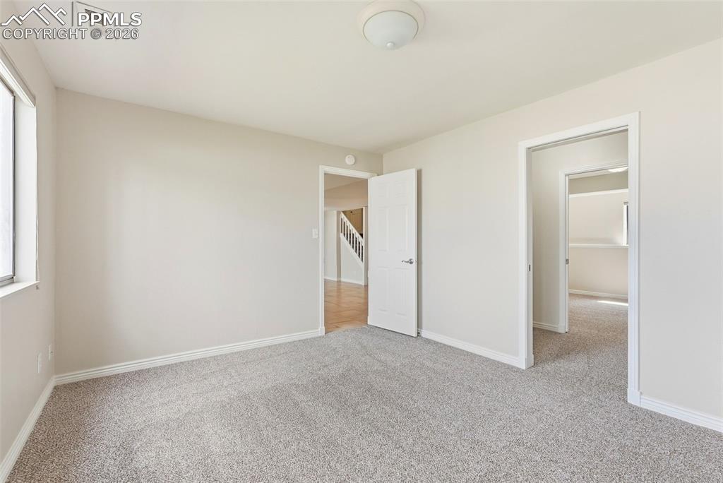 240 Bennington Drive Colorado Springs, CO 80906 - Photo 32 of 44 This room features light gray carpeting, white trim, and a window providing natural light