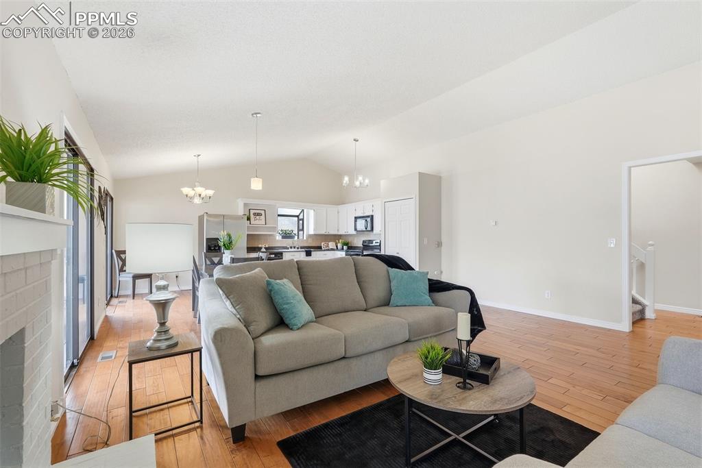 240 Bennington Drive Colorado Springs, CO 80906 - Photo 8 of 44 Living area with vaulted ceilings, hardwood flooring, and sliding glass doors