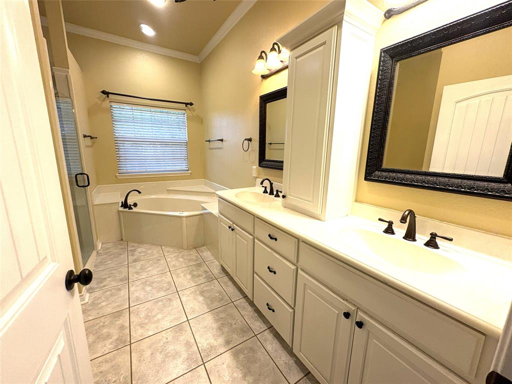 1170 Brazos Loop Gholson, TX 76705 - Photo 23 of 37 Bathroom featuring a corner soaking tub, a dual vanity with integrated sinks, and white cabinetry