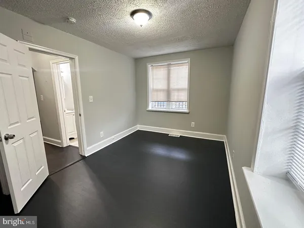 an empty room with wooden floor and window