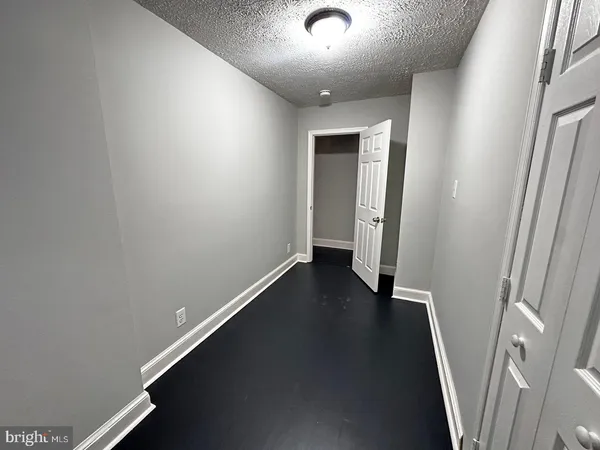 an empty room with wooden floor and entrance