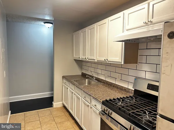 a kitchen with granite countertop a stove and a sink