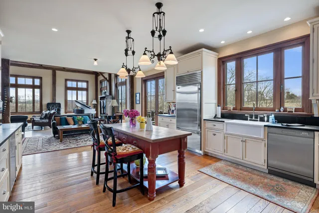 a view of a hallway with wooden floor and a bathroom