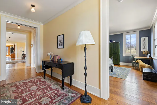 a view of a hallway with wooden floor and a living room