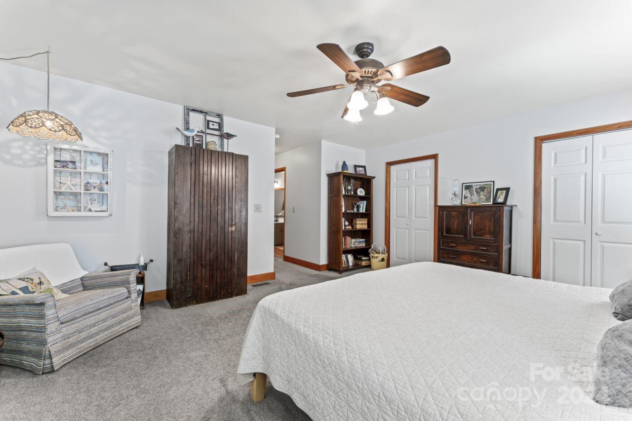 2440 Sloop Road Mount Ulla, NC 28125 - Photo 23 of 48 a bedroom with a large bed and a chandelier