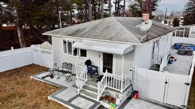 a view of a patio with table and chairs with wooden floor and fence