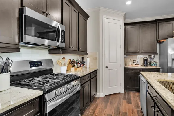 a kitchen with stainless steel appliances granite countertop a sink stove and refrigerator