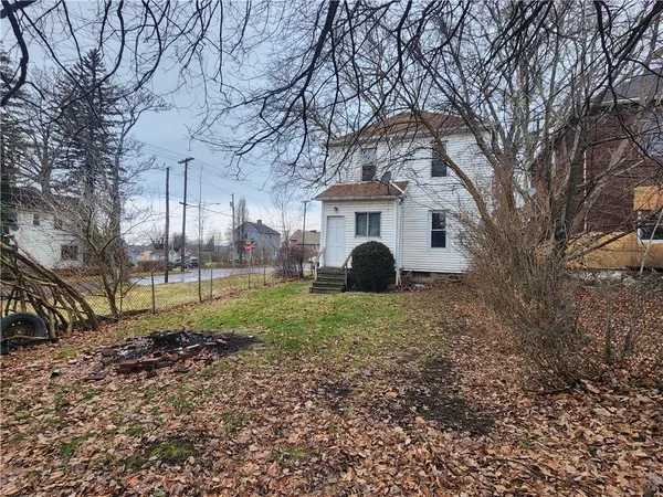 a view of a house with a yard and large trees