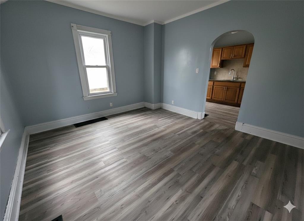 703 French Street Farrell, PA 16121 - Photo 3 of 14 a view of an empty room with wooden floor and a window