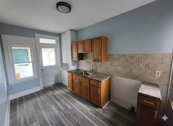 a kitchen with stainless steel appliances granite countertop a stove a sink dishwasher and a microwave oven with wooden floor