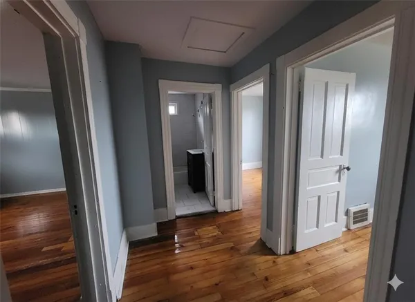a view of a hallway with wooden floor