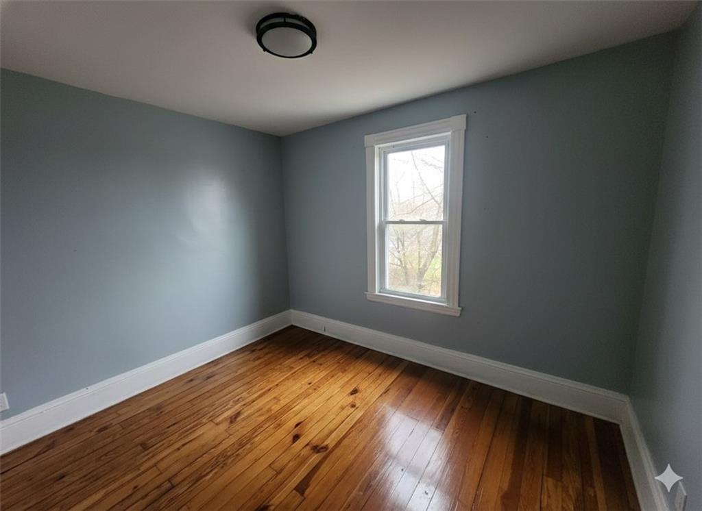 703 French Street Farrell, PA 16121 - Photo 9 of 14 an empty room with wooden floor and windows