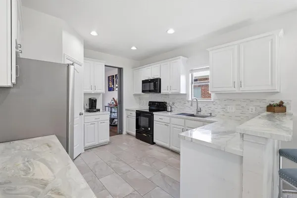a kitchen with white cabinets and stainless steel appliances