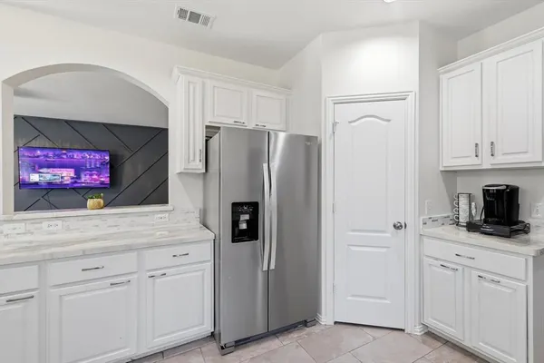 a kitchen with white cabinets and stainless steel appliances