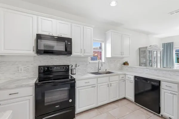 a kitchen with appliances a sink and cabinets