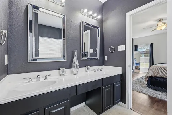 a en suite bathroom with a double vanity sink and a mirror